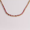 Video of pink tennis necklace on white background.