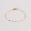 Video of gold chain bracelet on white background.