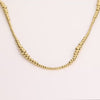 Video of a gold ball chain necklace on white background.