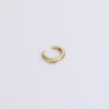 Gold ear cuff with gemstone on neutral background