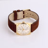 Video of gold watch with brown leather band on white background