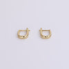 Video of gold huggie earrings on neutral background