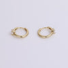 Gold huggies with white sapphire gemstone on neutral background