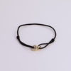 Black cord bracelet on neutral background