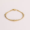 Video of a gold ball chain bracelet on white background.