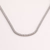 White sapphire tennis necklace on neutral background