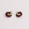 Video of a maroon and gold looped earrings on white background.