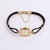 Video of black cord watch with gold face on white background