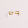 Video of a gold pearl hoop earrings on white background.