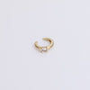 Gold huggie with gemstone on neutral background