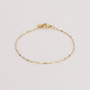 Video of gold chain bracelet on white background.
