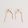 Video of gold bow earrings on white background.