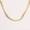 Video of a gold ball chain necklace on white background.
