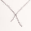 Video of white tennis necklace on white background.