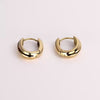 Video of gold hoop earrings on white background.
