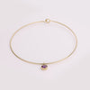 Video of gold collar necklace with gemstone pendant on white background.