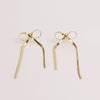 Video of gold bow earrings on white background.