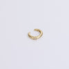 Gold ear cuff with gemstone on neutral background