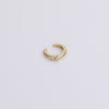 Gold ear cuff with gemstone on neutral background