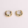 Video of gold hoop earrings on white background.
