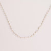 Video of a pearl chain necklace on white background.