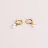 Video of a gold pearl hoop earrings on white background.