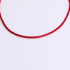 Red cord necklace on neutral background