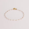 Video of a pearl chain bracelet on white background.